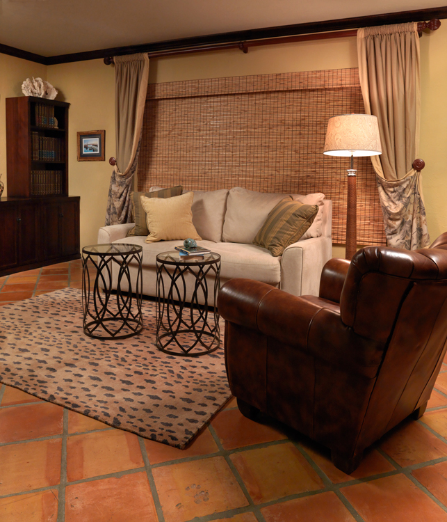 A comfortable study with sofa bed, leather chair and animal print rug.