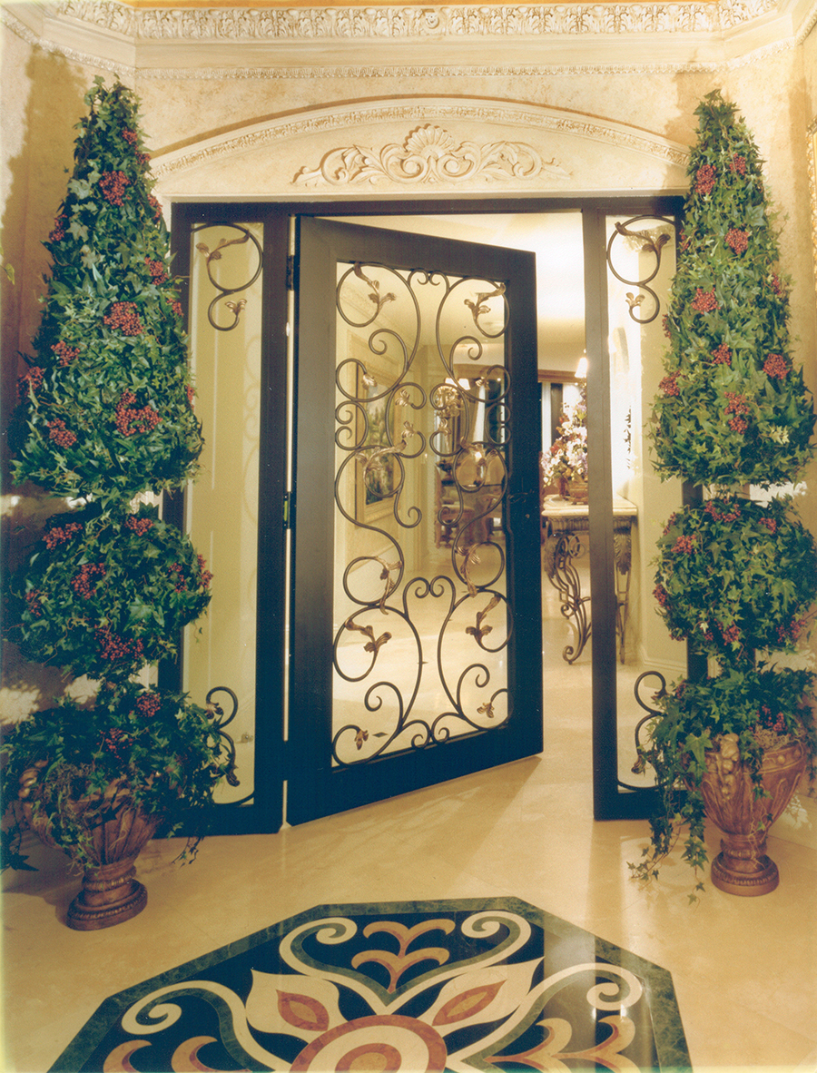A Wrought Iron door and marble floor medallion welcome visitors in this Tuscan Entry.